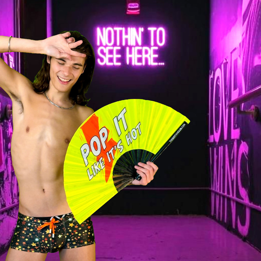 Man holding a Gay Poppers Rave Folding Bamboo Hand Fan from the Gay Fan Club- Pop It Like Its Hot 